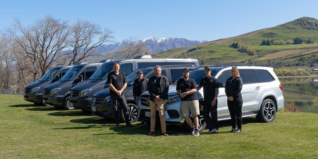 The Alpine Luxury Tours team in Queenstown standing in front of the fleet of Mercedes vehicles