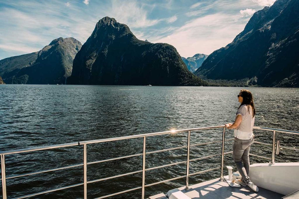 Milford Sound woman standing on deck of the fiordland jewel on a milford sound day trip with alpine luxury tours